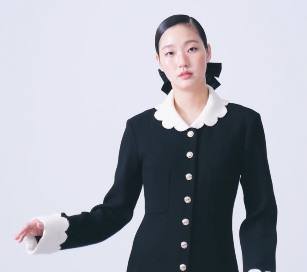 Kim Go-eun wearing a black outfit with a white scalloped collar and cuffs.